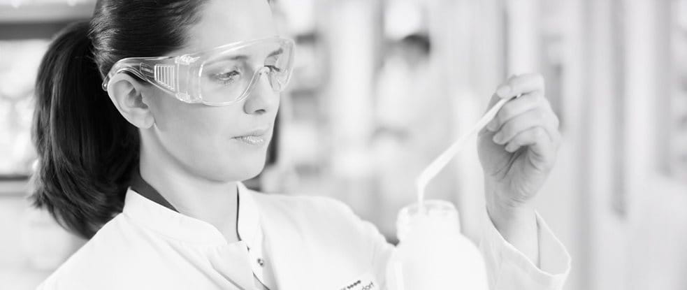 Wissenschaftlerin mit Schutzbrille testet ein Präparat