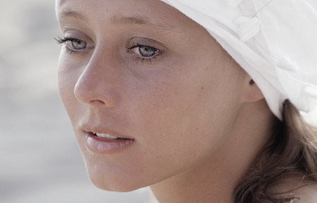 Frau mit weisser Kopfbedeckung.