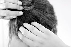 Eine Frau kratzt ihre juckende Kopfhaut